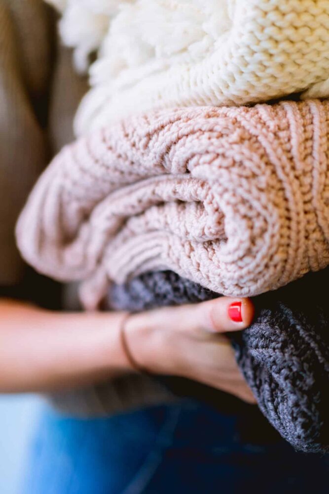 Future of Packaging Gen Z Report. Person holding folded clothes.